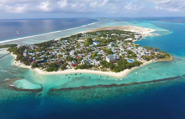 Aerial bird's-eye view of Thulusdhoo island surrounded by crystal clear ocean